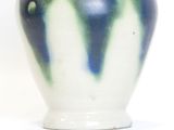 a blue and white vase sitting on a white surface