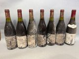 six bouteilles de vin sont alignées sur une table