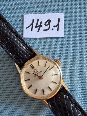 une photo d'une montre-bracelet en or montée sur un bracelet en cuir noir