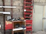 une étagère rouge sur laquelle sont posés des outils, dans un garage