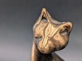 a bronze cat statue sitting on top of a table