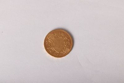 a gold coin on a white surface with a white background