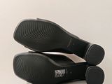a pair of black shoes sitting on top of a box