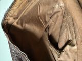 a brown leather bag with a zipper on the inside of it