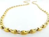 gros plan d'un collier en or sur une surface blanche