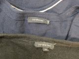 three sweaters are sitting in a box with labels on them