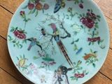 a plate with a bird design on it on a wooden table