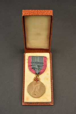 l'image d'une médaille dans une boîte entourée d'un ruban