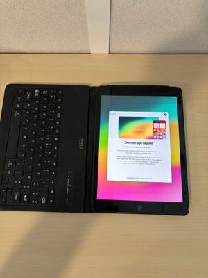 une tablette et un clavier posés sur une table
