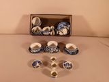 several cups and saucers are sitting in a box on a table