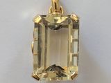 un pendentif en or jaune orné d'une émeraude au centre