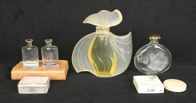 three bottles of perfume on a table with a wooden stand