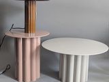 a table with a lamp on top of it next to a table with a lamp on top of it