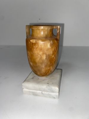 un vase posé sur un bloc de marbre
