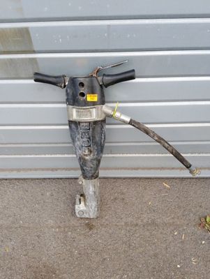 une image représentant une perceuse à laquelle est raccordé un tuyau