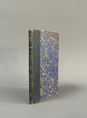 an old book with a blue cover sitting on top of a table