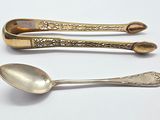 three spoons and two spoons sitting on a table