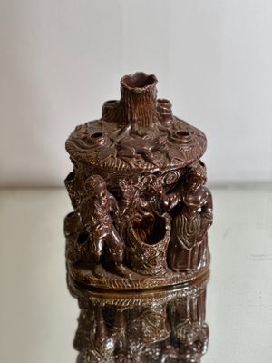 a small vase with a statue on it on a glass table