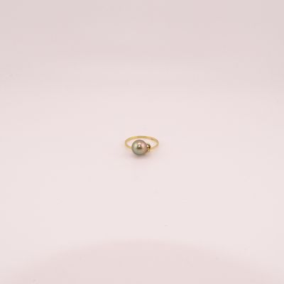 une photo d'une bague ornée d'une seule perle posée sur un fond blanc
