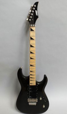 an electric guitar sitting on top of a white surface