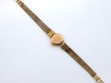 a gold plated watch with a mesh bracelet