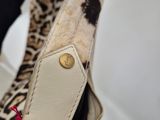 someone is holding a purse with a leopard print pattern on it