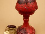 une lampe de table rouge munie d'un cordon
