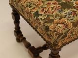 an old wooden bench with a floral upholstered seat