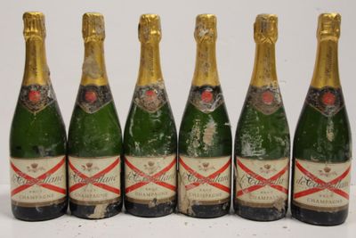 six bottles of champagne lined up in a row on a table