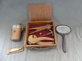 une boîte en bois contenant un miroir, une loupe, une paire de ciseaux et un miroir