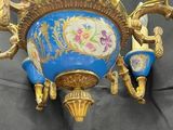 a blue and gold vase with flowers on it on a black surface