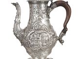une théière ancienne en argent posée sur un plateau muni d'une poignée en bois