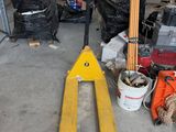 un chariot élévateur dans un garage, à côté d'autres outils
