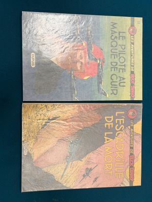Deux livres sont posés sur une surface bleue : l'un représente un homme et l'autre une femme.
