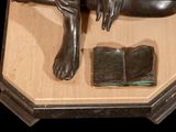a statue of a person laying down on a book