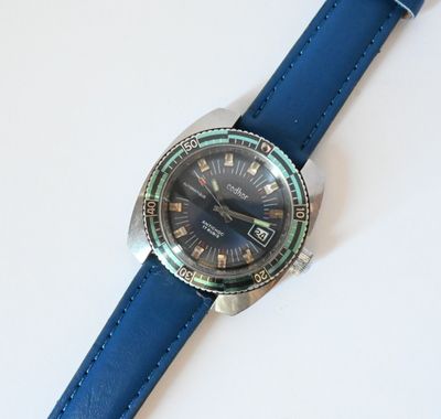 a close up of a wrist watch on a white surface