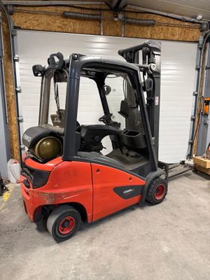 un chariot élévateur rouge garé devant une porte de garage