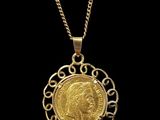 a gold coin pendant with a crown on a chain