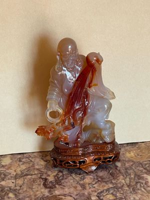a figurine of a man and a woman sitting on a rock