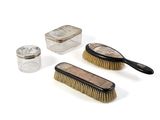 three brushes, a brush, and a glass jar on a white surface