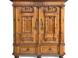 une vieille armoire en bois avec des gravures et des sculptures sur les portes