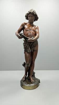 bronze statue of a man holding a book on a pedestal