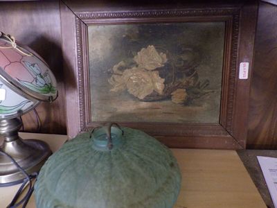 a green pumpkin sitting on a table next to a lamp