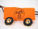 a pair of earrings that are sitting on top of an orange pouch