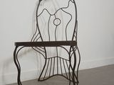 wrought iron chair in the shape of a fish on a stand