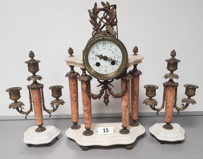 a clock that is sitting on top of a set of candles
