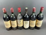 six bottles of wine are lined up in a row on a table