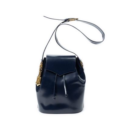 le petit sac seau en cuir bleu marine avec des finitions dorées