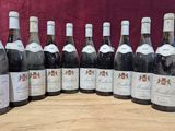 six bouteilles de vin sont alignées sur une table en bois
