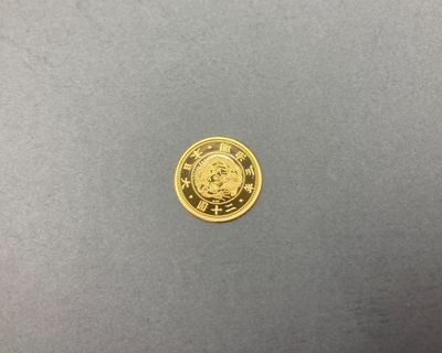 une pièce d'or posée sur une surface grise